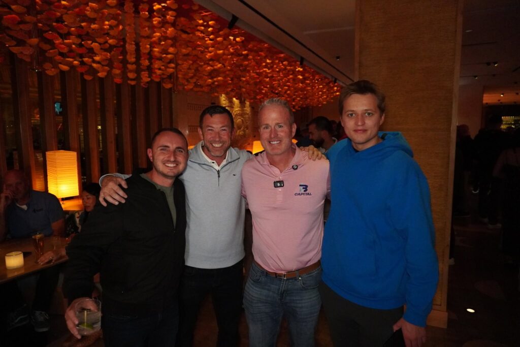 Marko Sipila at right with Lance Bachmann in a pink LB Capital polo, Lawrence Portnoy at left, and another guest